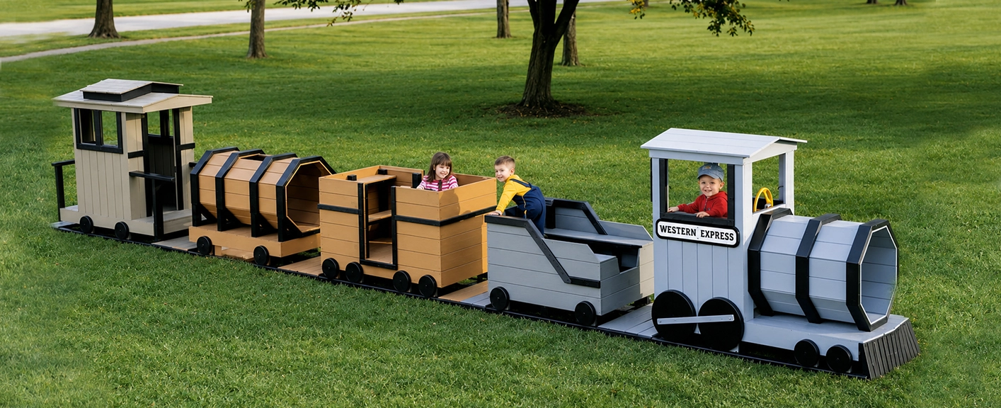 Children playing on an outdoor playground train with multiple cars in a grassy park